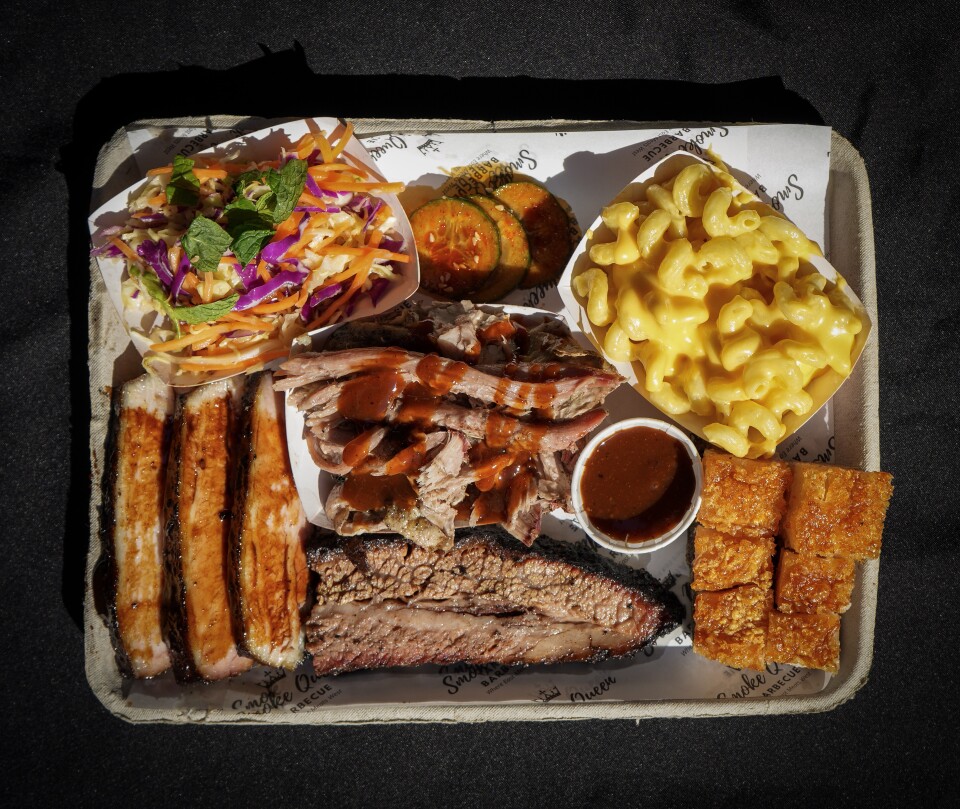 A tray filled with different barbecued meats and sides 