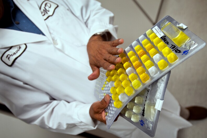 Patel holds samples of beach water that have incubated for an 18 to 14 hour period. Most bacteria they find is not harmful to beach goers. Patel estimates that a beach is closed because of a spill or other contamination one to two times each year.