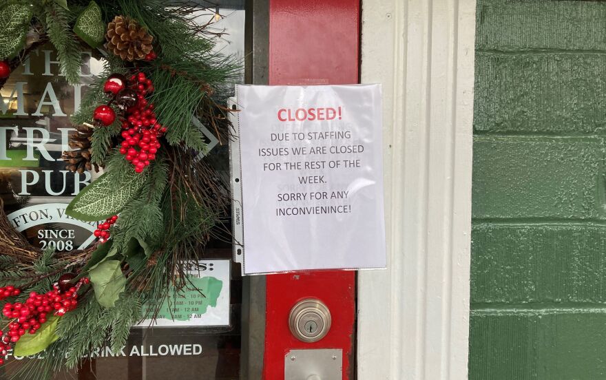 A paper sign on a red door that reads "Closed! Due to staffing issues, we are closed for the rest of the week. Sorry for any inconvenience!"