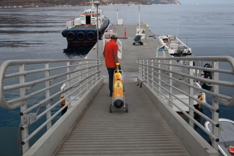 Supreeth Subbaraya, a master's candidate in engineering at USC, carries the submersible robot down the dock at the USC Wrigley Institute on Catalina Island.