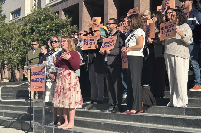 A crowd gathered holding signs