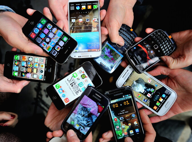 People show their smartphones on December 25, 2013.