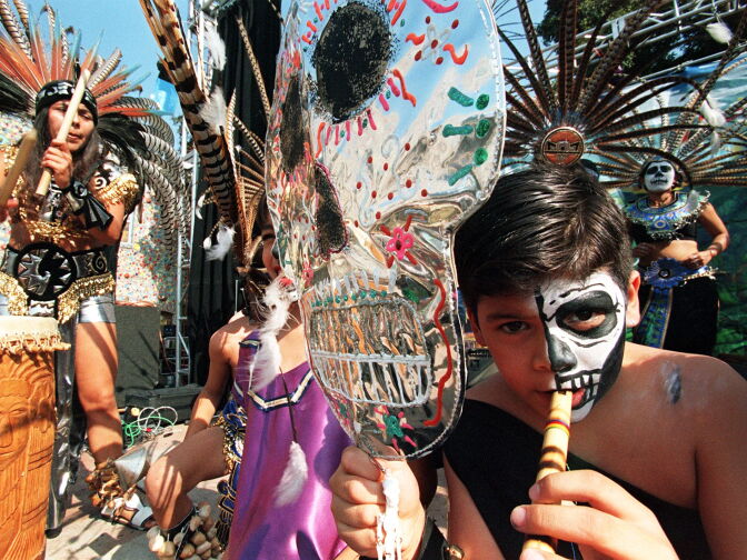 LOS ANGELES, UNITED STATES:  A boy plays the flute during a celebration of "The Day of the Dead"  01 November in East Los Angeles. The festival, both secular and religious, Catholic and pre-Columbian, is celebrated mostly by the Hispanic community of Los Angeles. Most other communities celebrate Halloween 31 October.   AFP PHOTO/Hector MATA (Photo credit should read HECTOR MATA/AFP/Getty Images)