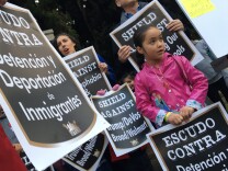 A student holds a protest sign that translates to "Shield Against Detention and Deportation of Immigrants" at an anti-Trump rally organized by teachers unions at Mar Vista's Grand View Boulevard Elementary School on Thurs., Jan. 19, 2017.