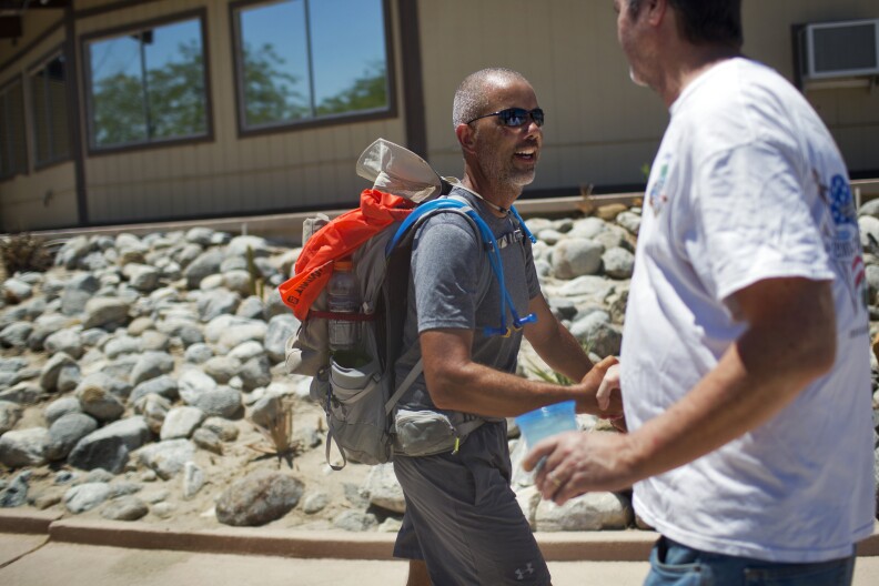 Darryl Monroe, right, greets Randy Brown before lunch at Vista Del Mar Clubhouse during his six-day walk around the Salton Sea on Friday, June 12, 2015. Monroe has been following Brown's walk online and came to the lunch to show support.