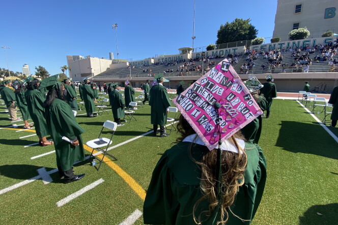During the commencement ceremony at Belmont High School, an L.A. Unified School District campus near downtown, a graduating senior wears green robes and a mortarboard decorated with the words: "I wanted to give up but then I remembered who I was." She's standing on a football field next to other graduating students who are assembled at socially-distanced folding chairs.