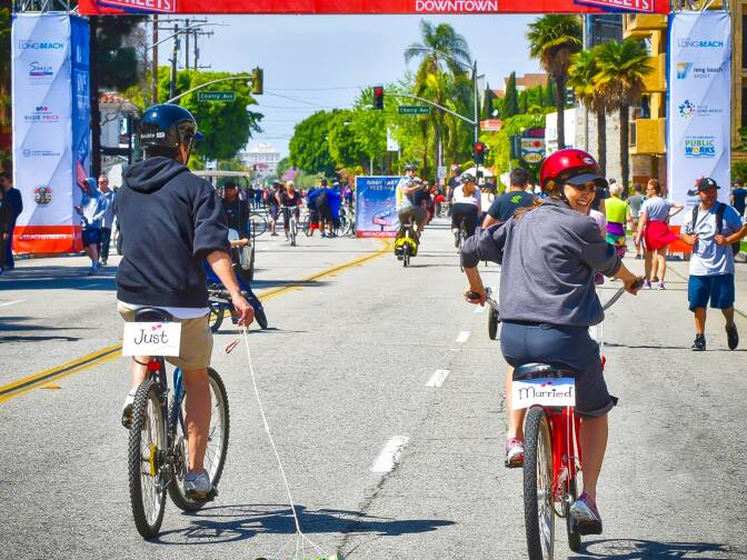 Newly married bicyclists pedal through Long Beach during a Beach Streets event.