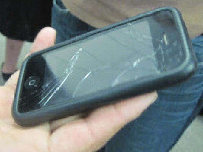 Manuel Gallegos displays his iPhone to show the damages that occurred during a struggle with police at a press conference in Downtown LA on June 4, 2010