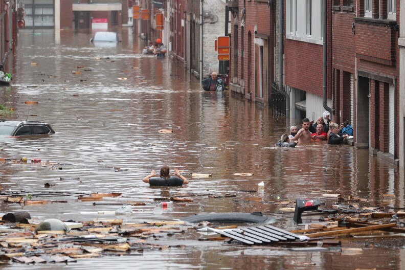 A woman tries to move in a flooded street following heavy rains in Liege, Belgium, on Thursday.
