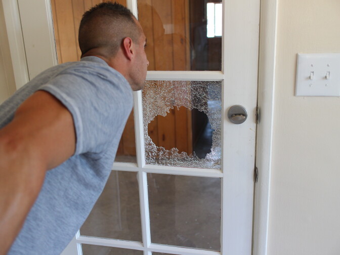 A Martinez surveys a foreclosed home in San Bernardino that has been vandalized. 