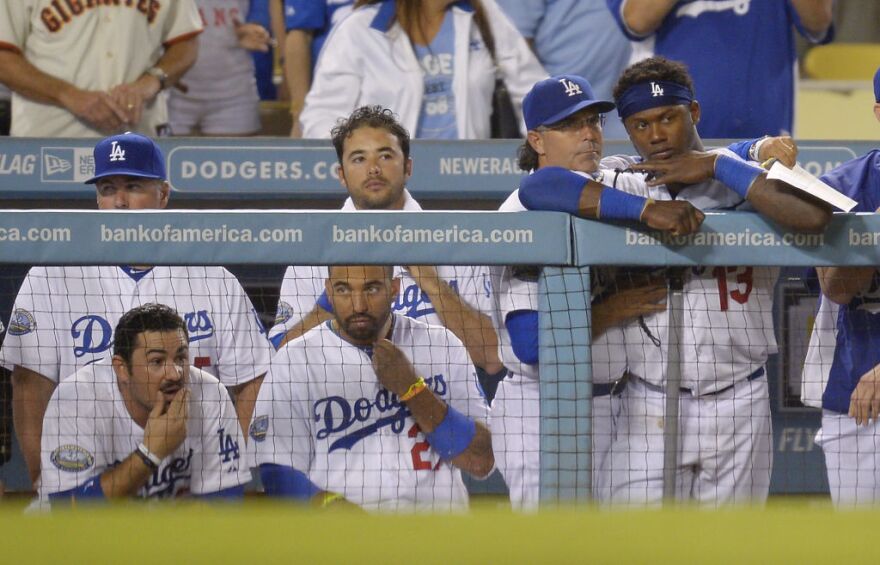 Members of the Los Angeles Dodgers watch from the dugout during the ninth inning of their baseball game against the San Francisco Giants, Tuesday, Oct. 2, 2012, in Los Angeles. The Giants won the game 4-3. With that loss, the Dodgers were eliminated from playoff contention. (AP Photo/Mark J. Terrill)