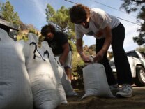 Patty Kindel (R) prepares sandbags as residents prepare in advance of the first rain storm since before the massive Station fire began for the possible major mudslides below the rugged San Gabriel Mountains, scorched and denuded by the 250-square-mile blaze, on October 9, 2009 in La Canada Flintridge, California.