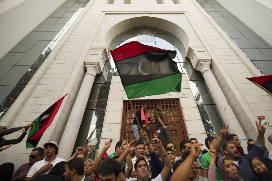 Tunisians and Libyans living in Tunisia wave Libya's National Transitional Council flags as they celebrate on October 20, 2011 in the Mohamed V street of Tunis after the announcement of the death of Libyan strongman Moamer Kadhafi. Kadhafi who was killed when his hometown Sirte fell after refusing to surrender, ruled his North African country for 42 years before being ousted in August. AFP PHOTO / LIONEL BONAVENTURE (Photo credit should read LIONEL BONAVENTURE/AFP/Getty Images)