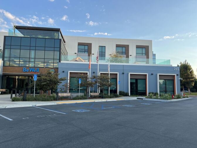 The exterior of a building has a terra cotta-colored stone wall with the words: County of Orange County Administration North 