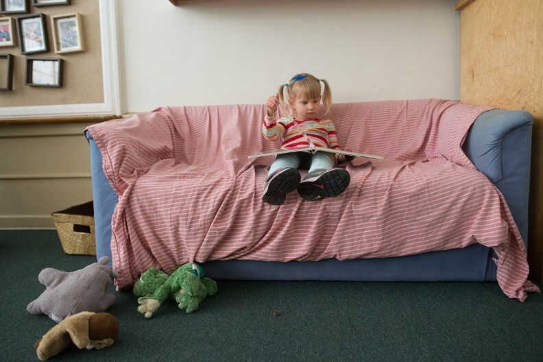 A preschool student at the Child Educational Center reads during play time. Civil rights attorney Lisa Bloom wants adults to “focus on little girl’s brains and on their achievements and accomplishments...not on whether they’re having a good hair day.”