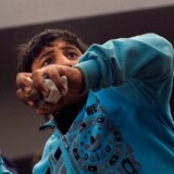 An anti-government protester throws rocks at pro-government supporters near a highway overpass on the edge of Tahrir Square. 