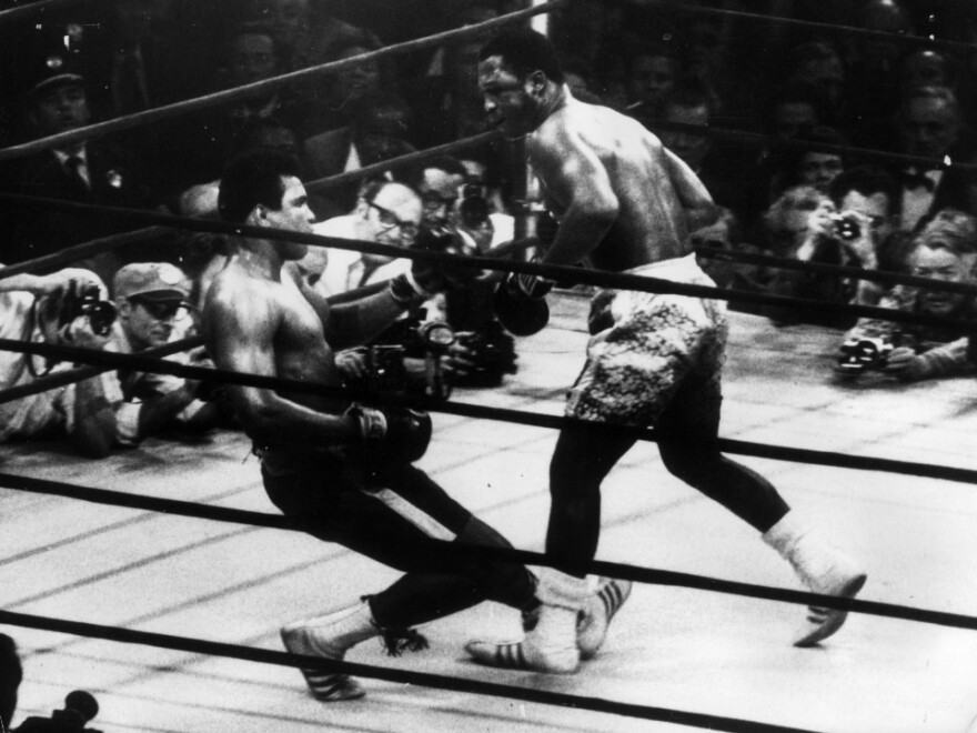 Muhammad Ali (right) goes down in the 15th round of a title fight in 1971 to a left hook from world heavyweight champion Joe Frazier. 