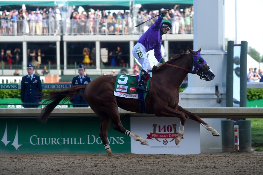 California Chrome #5, ridden by Victor Espinoza, crosses the finish line to win the 140th running of the Kentucky Derby at Churchill Downs on May 3, 2014 in Louisville, Kentucky.