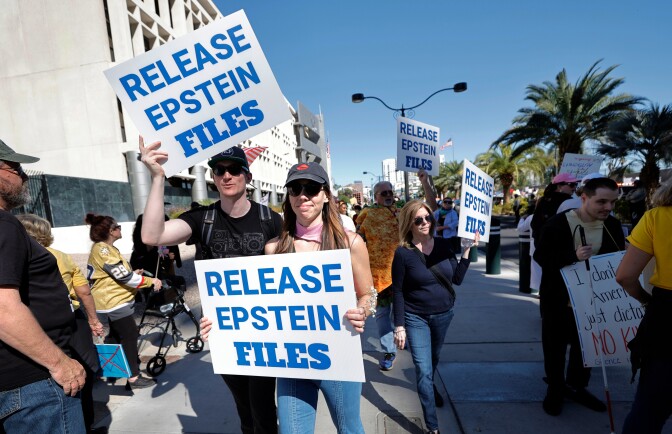People hold signs reading: Release Epstein files