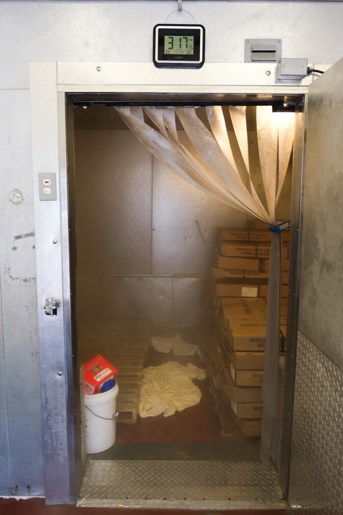 An industrial freezer with cardboard boxes stacked.