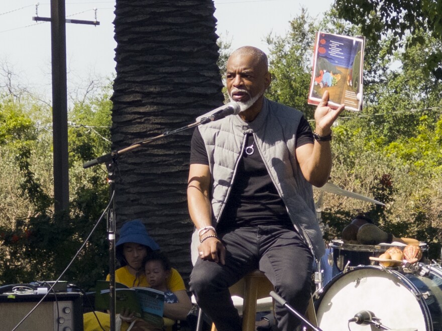a man holds a book and looks into a presumed crowd