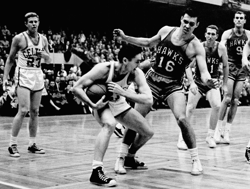 FILE - In this March 30, 1958, file photo, Boston Celtics'  Bill Sharman holds the ball as St. Louis Hawks' Cliff Hagan (16), defends, during the second half of an NBA Finals basketball game in Boston. Sharman, the Hall of Famer who won NBA titles as a player for the Boston Celtics and a coach for the Los Angeles Lakers, has died. He was 87.  Sharman died Friday, Oct. 25, 2013, at his home in Redondo Beach, the Lakers announced.