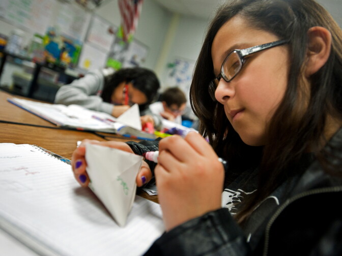 Sixth grader Reyna Ugalde highlights in pink the edges of her handmade polyhedron.