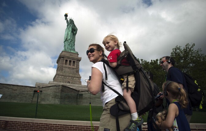 A family walks by the Statue of Liberty on the first day it is open to the public after Hurricane Sandy on July 4, 2013 on the Liberty Island in New York City. Little do they know the name F. Hopkinson Smith, who designed the base of the statue.