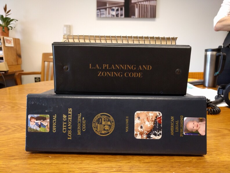The 3-inch binder on the bottom is what the LA city planning code looks like now. The one in the middle is what it was in 2002. And the small spiral-bound book on the top is what it looked like in 1966.