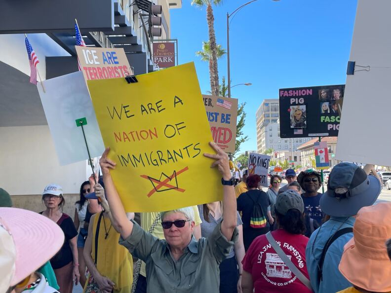 Protesters hold anti-Trump signs.