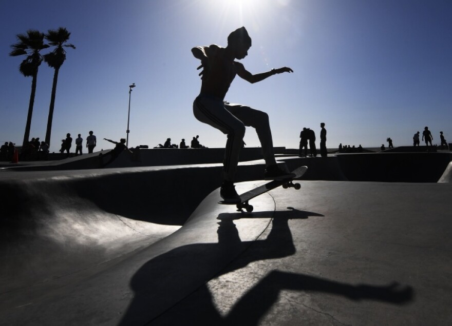 A skateboarder on a ramp seen in silhouette.