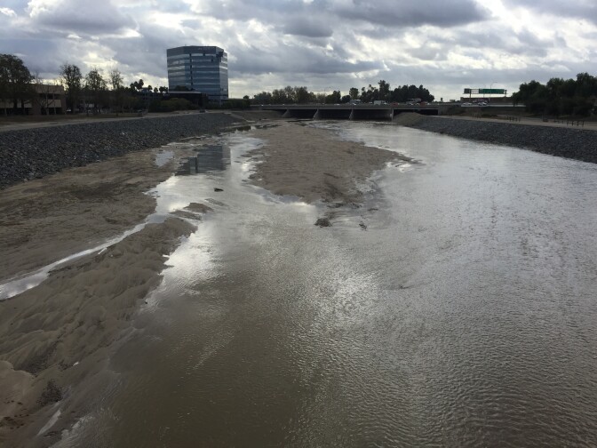 Storm waters flow steady down the Santa Ana River in Orange where lots of homeless people camp. January 7, 2015