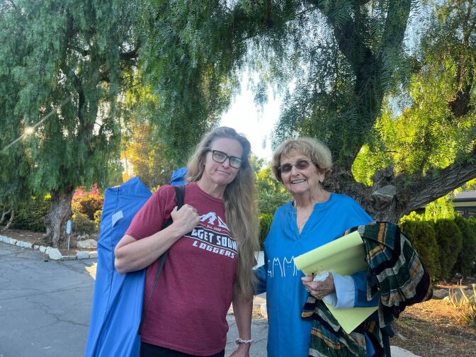 Two women in front of a house.
