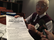 Bill Shishima holds up a replica of the poster that appeared in his neighborhood. 