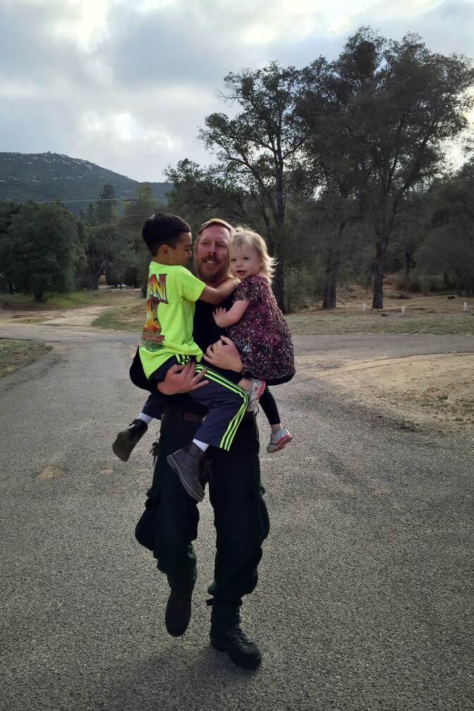 Jim Huston, Superintendent of Laguna Interagency Hotshot Crew at the US Forest Service, grabs his children Thomas, 7, and Hannah, 3. Hotshot crews can spend weeks at a time away from their families. 