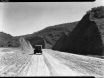 The unpaved Sepulveda Boulevard after completion in 1930. The hills have been cut back to widen the roadway, which is paved with graded gravel, as it was for most of the hilly portion of the road.  Hard pavement was added incrementally over the new 20 years.