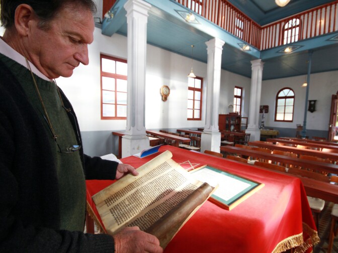 Abraham Kreiserman, the president of the Jewish community of Villa Clara, shows a portion of a Torah scroll at Beth Iacob Synagogue in Villa Clara.