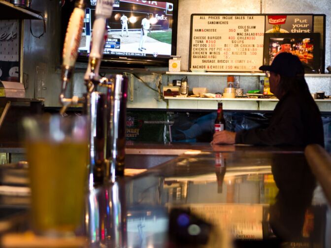 A customer watches televison as he drinks his beer in King Eddy Saloon.