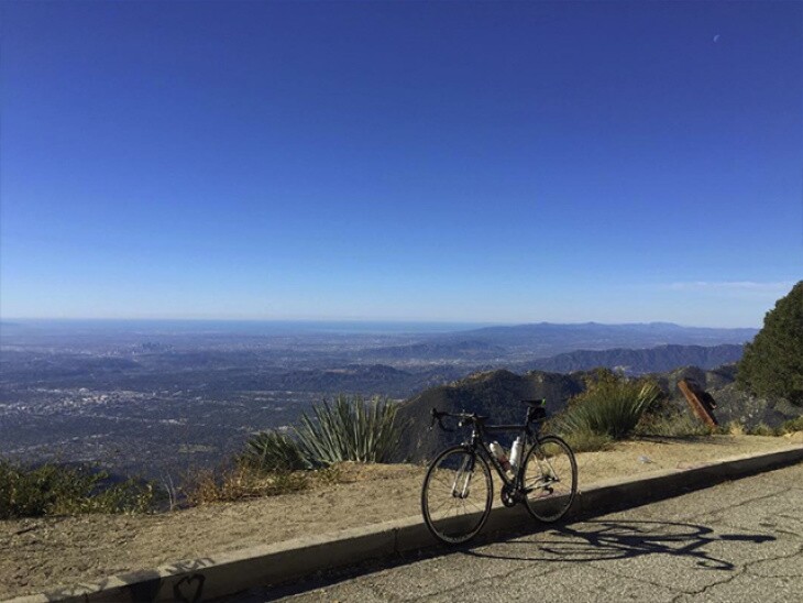 A solitary bike rests upright atop Mt. Wilson, offering sprawling views into the distance on a bright, sunny day.