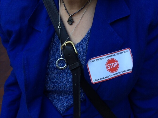 Disability Rights California attorney Ann Menasche wears an anti-Laura's Law sticker at the Orange County Board of Supervisors meeting.
