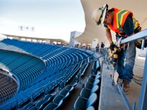 Luis Magdaleno, an electrician for Morrow Meadows, drills holes for wiring in handicap stalls, so that attendees can plug in their electronics. Renovations are taking place at Dodger Stadium before opening day on April 1. Magdaleno has been working on the park for four weeks.