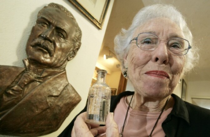 Catherine Mulholland, pictured in 2006 with a bust of her grandfather, William, and a souvenir bottle of water from him.