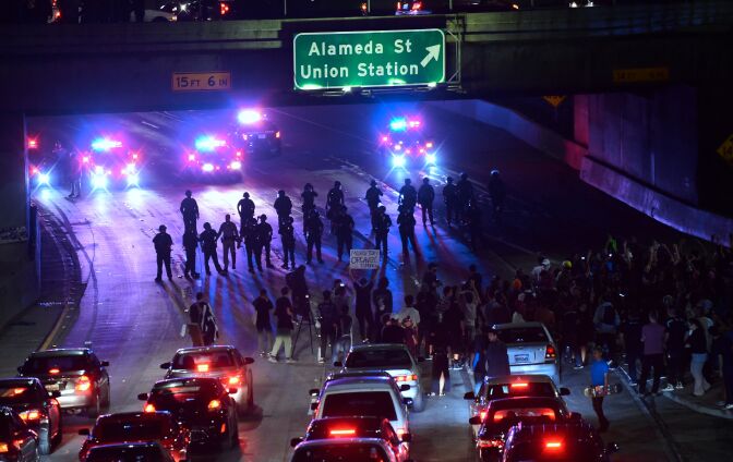 Police and protesters face off on a freeway in downtown Los Angeles, California after midnight early on November 10, 2016 as protesters angry over Donald J. Trump's election as the next US president marched in downtown Los Angeles through the evening and shut down portions of the Hollywood (101) Freeway.
Thousands of protesters rallied across the United States expressing shock and anger over Donald Trump's election, vowing to oppose divisive views they say helped the Republican billionaire win the presidency. / AFP / Frederic J. BROWN        (Photo credit should read FREDERIC J. BROWN/AFP/Getty Images)