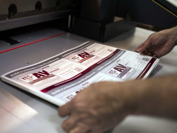 Account Executive Scott Newman demonstrates how a manual cutter slices mailers for Measure AV at Mellady Direct Marketing in Santa Clarita, Calif. on Thursday morning, Oct. 6, 2016. Mailers can go after different voters in different ways, based on voter data that campaigns can buy.