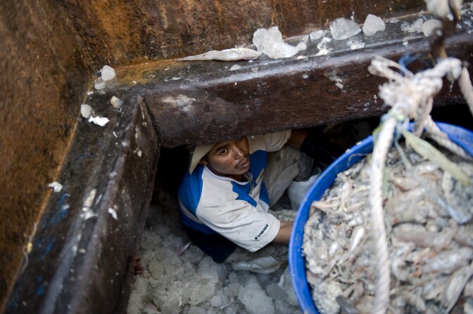 This picture taken on February 25, 2010 shows migrant workers from Cambodia at work on a fishing boat in Mahachai, on the outskirts of Bangkok. More than one million migrants in Thailand face possible deportation and abuse if they fail to meet a deadline this week to register with authorities, a rights watchdog said. Thailand has ordered all citizens from neighbouring Myanmar, Cambodia and Laos to register and verify their nationality or risk deportation, as part of an ongoing clampdown on immigration.  AFP PHOTO/ Nicolas ASFOURI (Photo credit should read NICOLAS ASFOURI/AFP/Getty Images)
