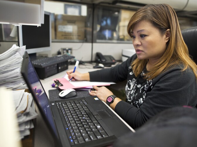 Grace Bescoby, a registered nurse and mental health counselor on the Mental Evaluation Unit's SMART team, looks for possible hospitals where the man in custody could be taken in at the LAPD's Rampart Division on Thursday, Dec. 11, 2014.