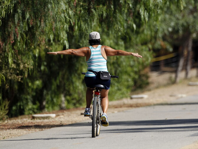 A woman bikes along the Whittier Greenway Trail in Whittier, Calif., on Monday, Sept. 1, 2014.  (AP Photo/Nick Ut)
