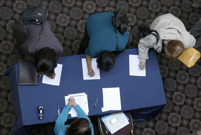 In this Wednesday, Jan. 22, 2014, photo, job seekers sign in before meeting prospective employers during a career fair at a hotel in Dallas. The Labor Department releases weekly jobless claims, on Thursday, Jan. 23, 2014. (AP Photo/LM Otero)