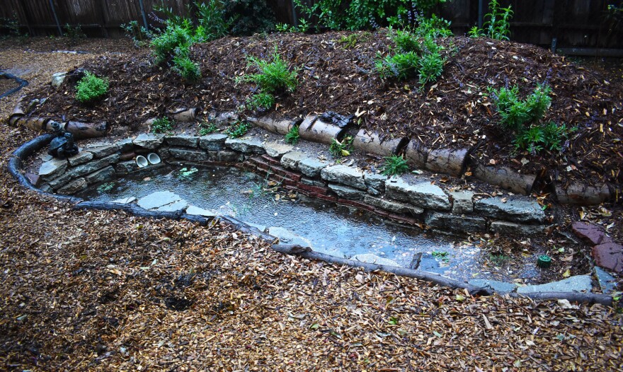 A hole in the ground lined with concrete and filled with water.