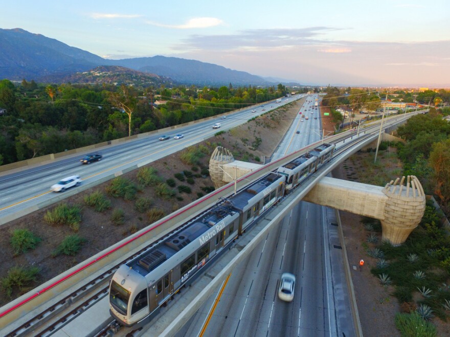 A Gold Line train heads over the eastbound 210 toward Arcadia Station.